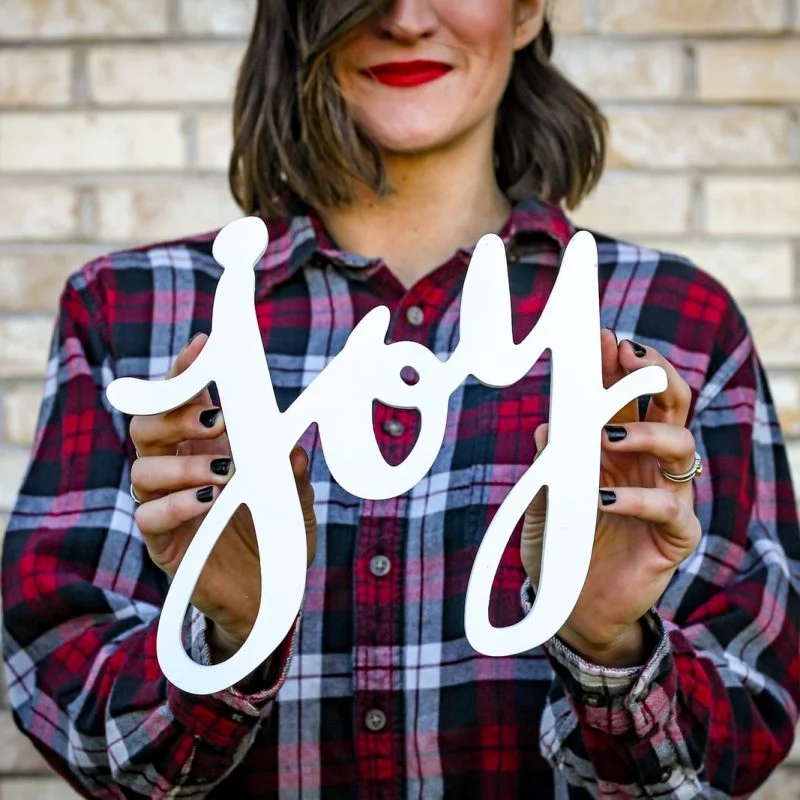 woman holding joy text
