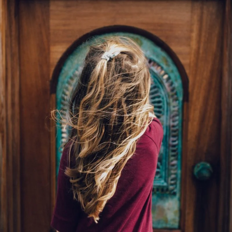 man wearing red sweater in front of door