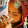 selective focus photography of girl drinking water