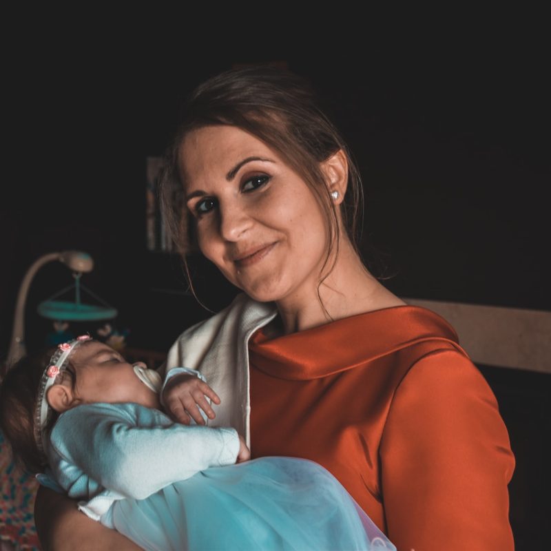 smiling woman carrying sleeping baby
