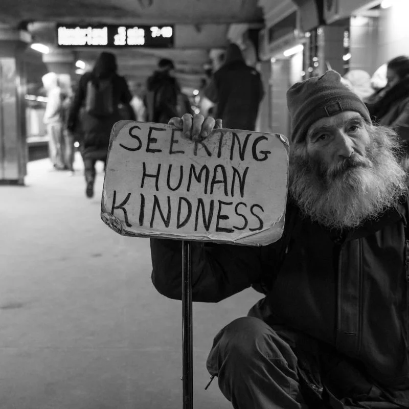 man holding card with seeking human kindness text