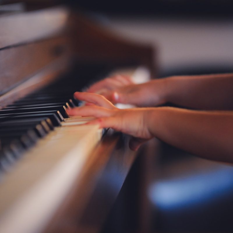 person playing upright piano