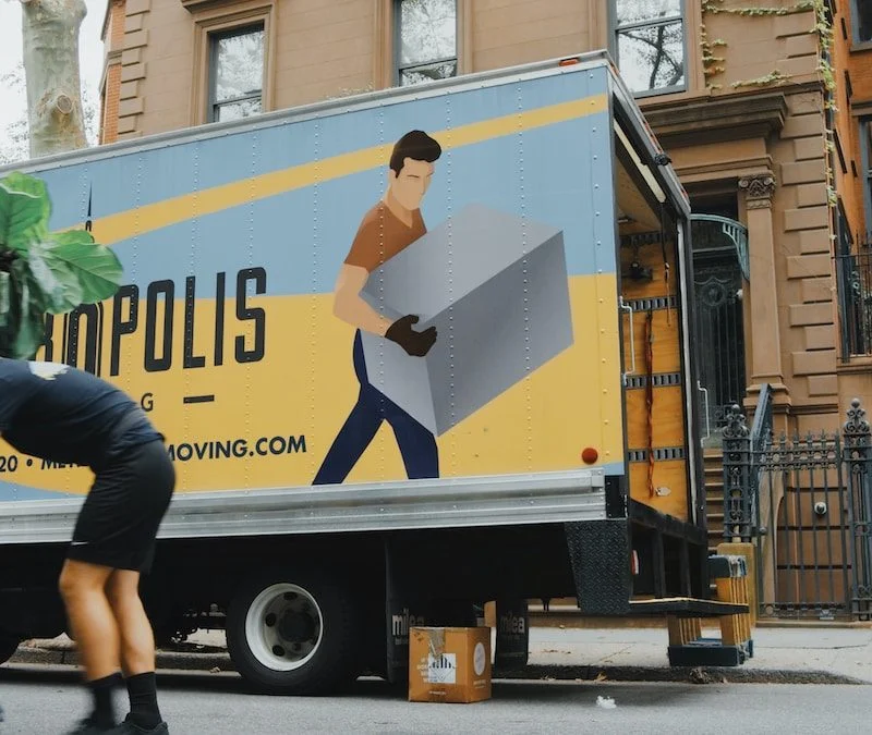 woman in blue shorts and black boots standing beside yellow and white truck during daytime