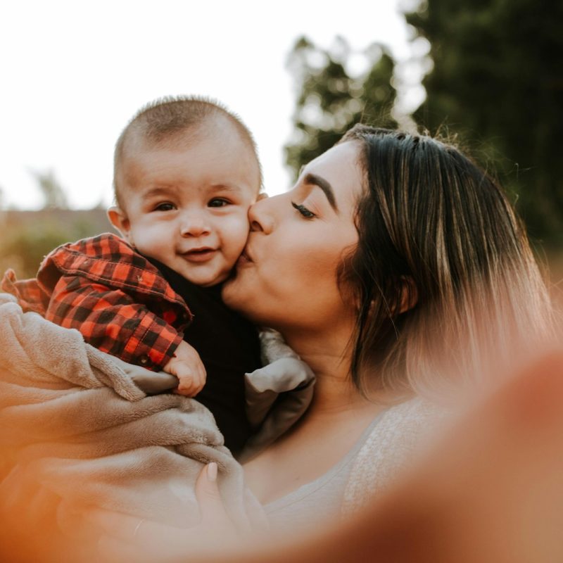 woman kiss a baby while taking picture