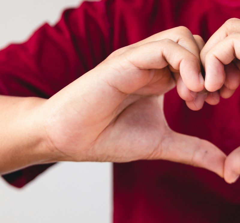 a person making a heart with their hands