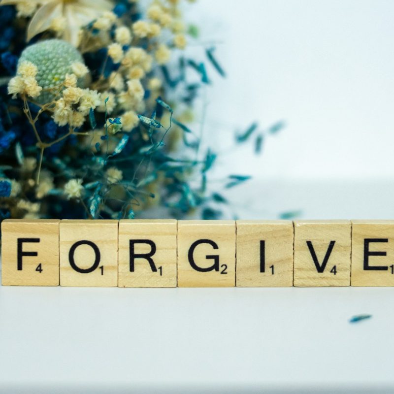 a wooden block that says for give next to a bouquet of flowers