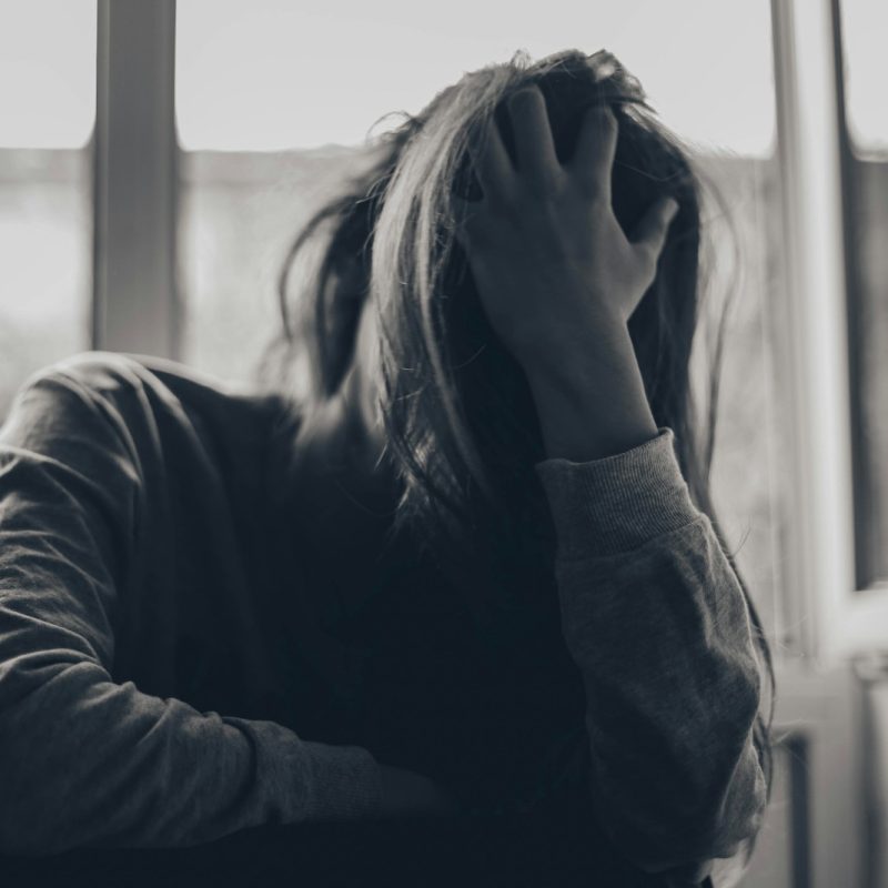 grayscale photography of person covering face