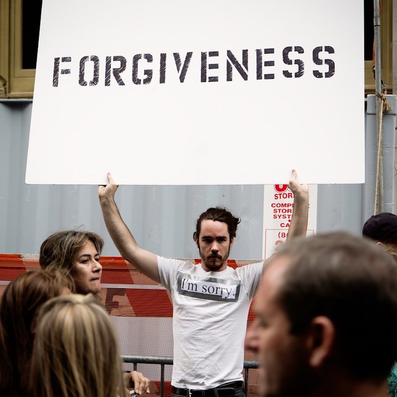 person holding Forgiveness poster
