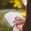 selective focus photography of person reading book