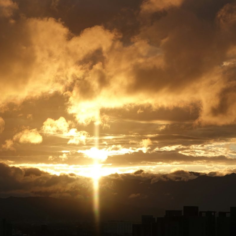 Golden sunset illuminates the cloudy sky.