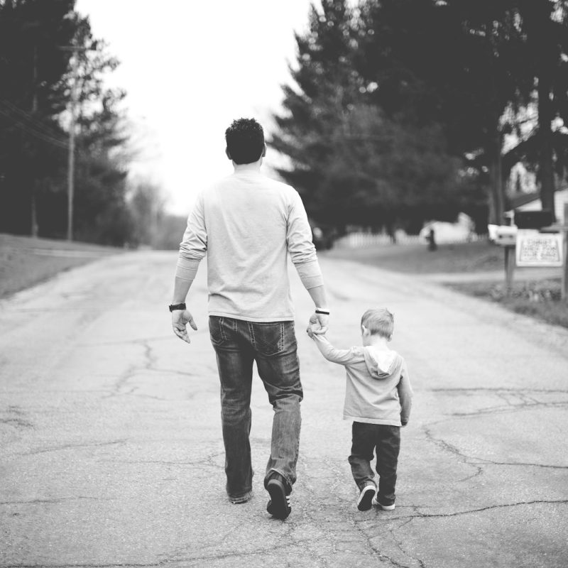 man holding baby's hand